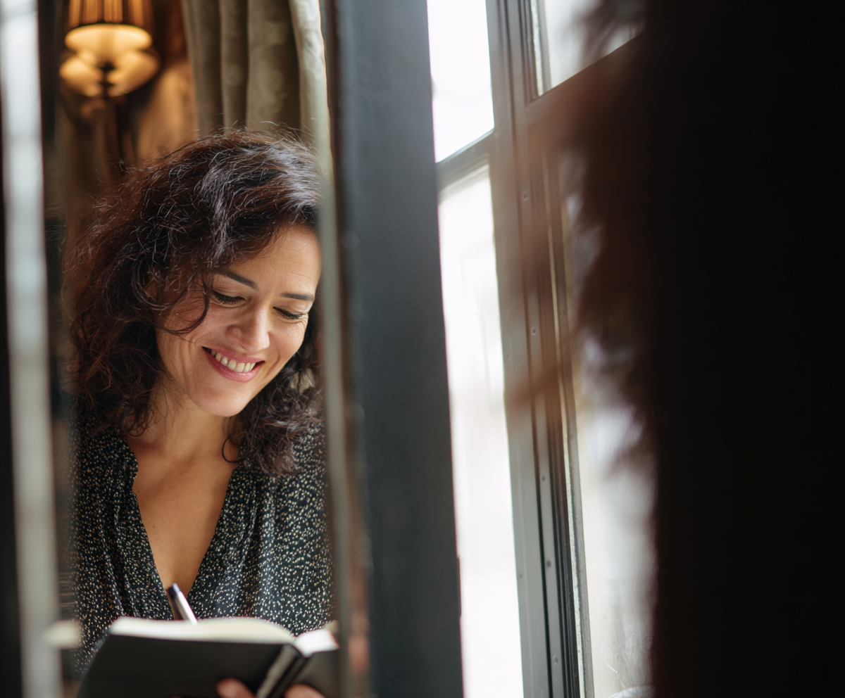 Woman journaling or smiling at her reflection
